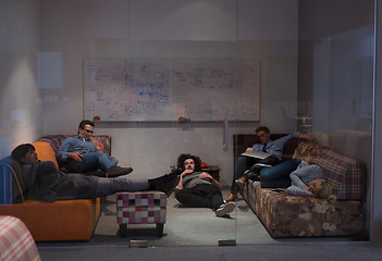 Image showing software developers sleeping on sofa in creative startup office