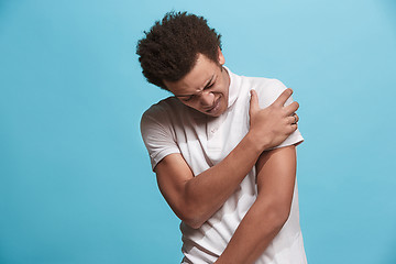 Image showing Young man overwhelmed with a pain in the shoulder.