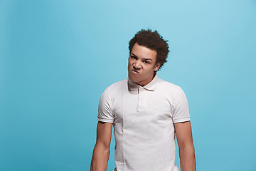 Image showing The young emotional angry man screaming on blue studio background