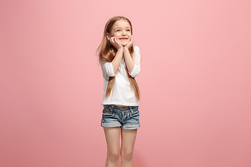 Image showing The happy teen girl standing and smiling against pink background.