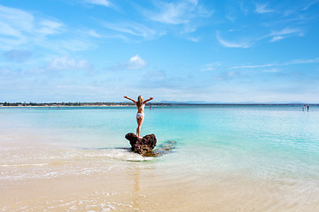 Image showing Woman wearing white swimsuit at idyllic beach feeling good