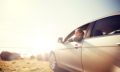 Image showing happy teenage girl or young woman in car