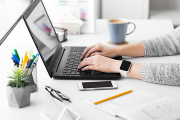 Image showing designer with smart watch and laptop at office