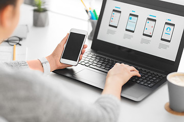 Image showing web designer with smartphone and laptop at office