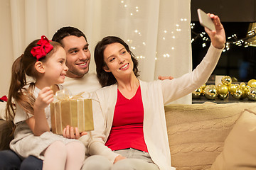 Image showing happy family with christmas present at home