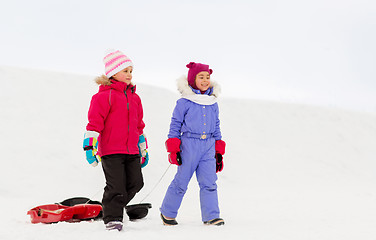 Image showing happy little girls with sleds walking in winter