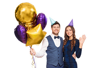 Image showing happy couple with party caps and balloons