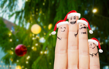 Image showing fingers in santa hats over christmas tree