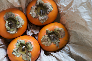Image showing Four kaki fruits (persimmon) in box. Top view