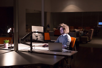 Image showing man working on computer in dark office