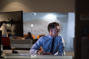 Image showing man working on computer in dark office