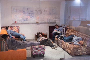 Image showing software developers sleeping on sofa in creative startup office