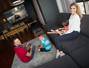 Image showing Happy family playing a racing video game