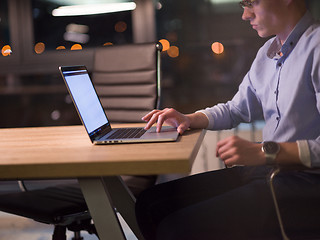 Image showing man working on laptop in dark office