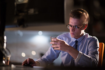 Image showing man using mobile phone in dark office