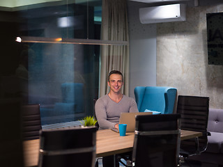 Image showing man working on laptop in dark office