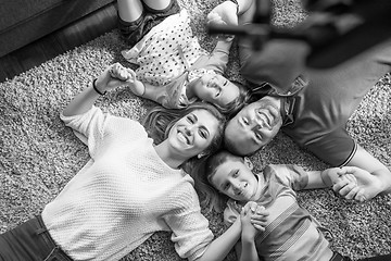 Image showing happy family lying on the floor