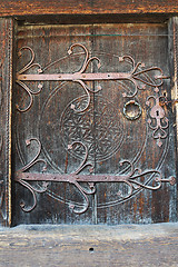 Image showing old wooden door with carved metal handle