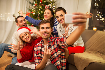 Image showing friends celebrating christmas and taking selfie