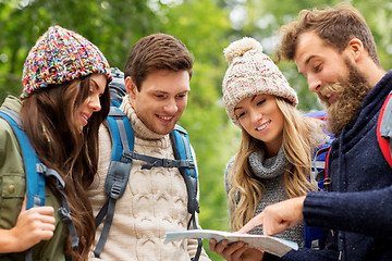 Image showing friends or travelers hiking with backpacks and map