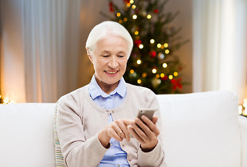 Image showing senior woman with smartphone at home on christmas