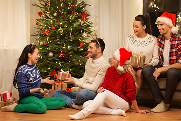 Image showing friends celebrating christmas and giving presents