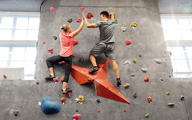 Image showing man and woman climbing a wall at indoor gym