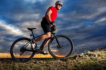 Image showing Man in helmet and glasses stay on the bicycle