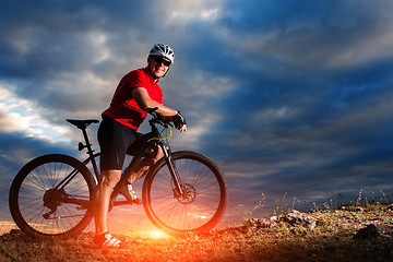 Image showing Man in helmet and glasses stay on the bicycle