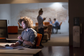 Image showing man working on computer in dark office