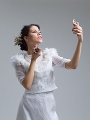 Image showing bride paints lips with lipstick