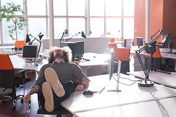 Image showing businessman sitting with legs on desk