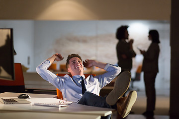 Image showing businessman sitting with legs on desk at office