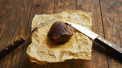 Image showing Fork and knife near roasted meat