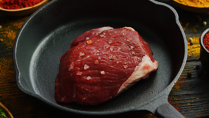 Image showing Meat with spices on skillet