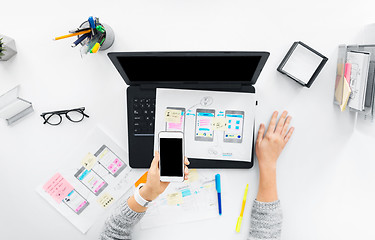 Image showing web designer with smartphone and laptop at office