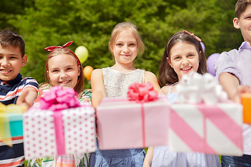 Image showing happy kids with gifts on birthday party in summer