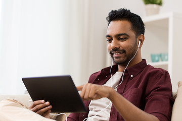 Image showing man in earphones with tablet pc listening to music