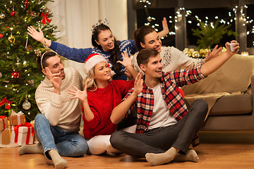 Image showing friends celebrating christmas and taking selfie