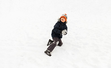 Image showing happy little boy playing with snow in winter