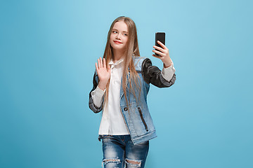 Image showing The happy teen girl standing and smiling against pink background.