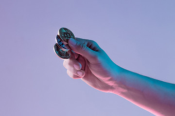 Image showing Male hand with golden bitcoin on blue background