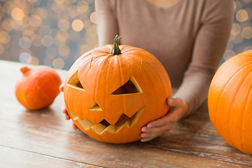 Image showing close up of woman with halloween pumpkin at home