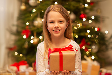 Image showing smiling girl with christmas gift at home