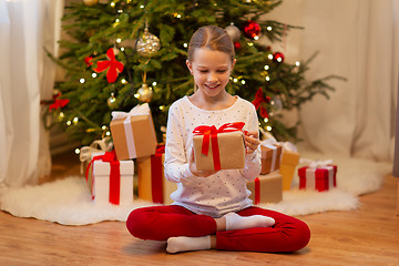 Image showing smiling girl with christmas gift at home