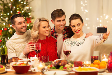 Image showing friends taking selfie at christmas dinner