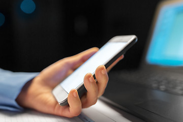 Image showing close up of hand with smartphone at night office