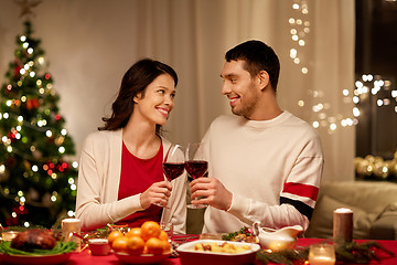 Image showing happy couple drinking red wine at christmas dinner