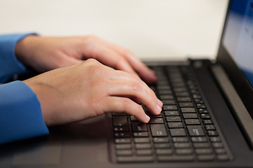 Image showing close up of female hands with laptop typing