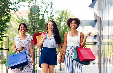 Image showing happy women with shopping bags walking in city